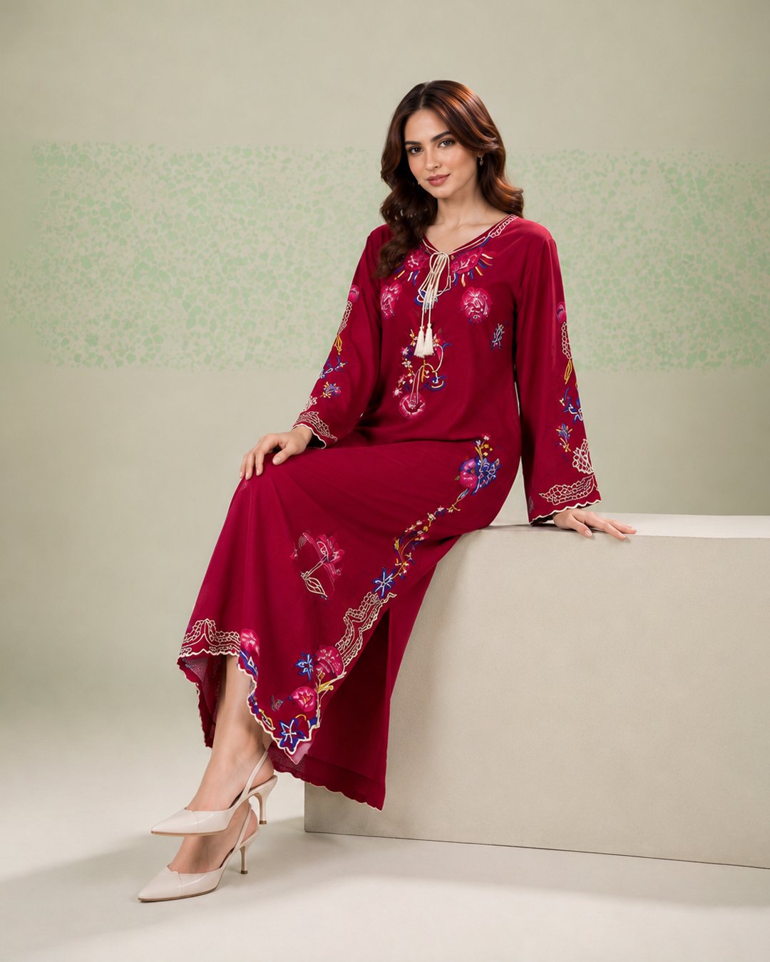 Red embroidered silk kaftan, seated side view on a block