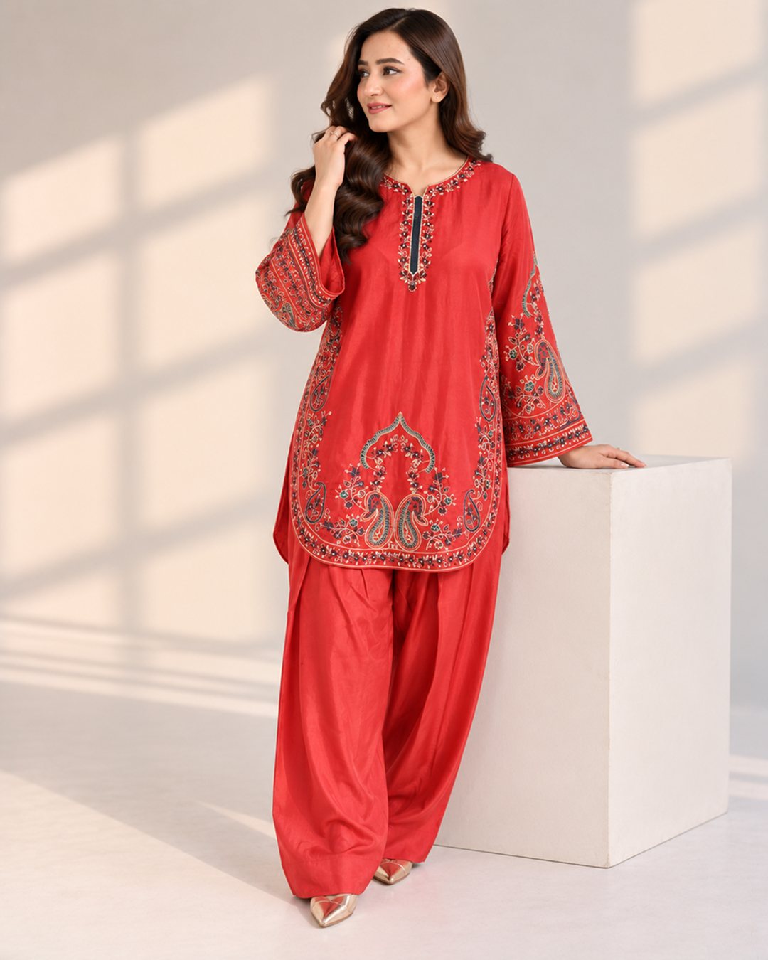 Rust Orange embroidered silk 2 piece suit, standing beside a white block, full-length front view